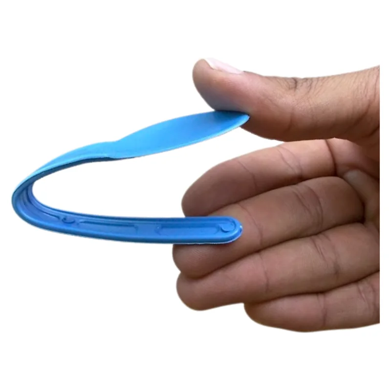 Colher média azul dobrada ao meio entre os dedos